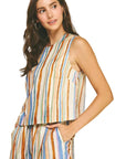 Woman wearing a sleeveless striped top and pants on a beige background