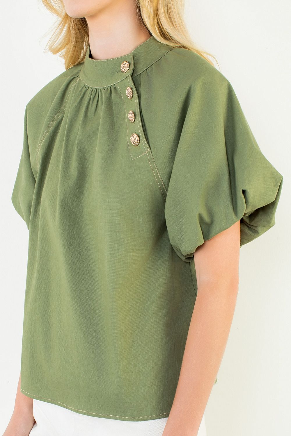 A model posing in the Olive Gold Button Blouse by THML, a cotton-spandex woven blouse, from Chatsworth Boutique in Fairhope, Alabama.