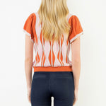 Front view of the Orange Ruffle Knit Blouse by THML, showing the ruffle detail and wavy print, from Chatsworth Boutique.