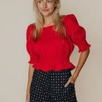 Close-up detail of the ruffle hem and stitching on the Ruby Top in red by LaRoque, from Chatsworth Boutique.