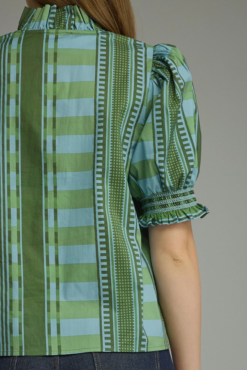 Close-up detail of the ruffle neckline and smocked sleeve on the Stripes and Dots Blouse in green by Entro, from Chatsworth Boutique.