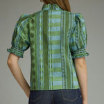 A model styling the Stripes and Dots Blouse in green by Entro, a green and teal mixed print top, from Chatsworth Boutique in Fairhope, Alabama.