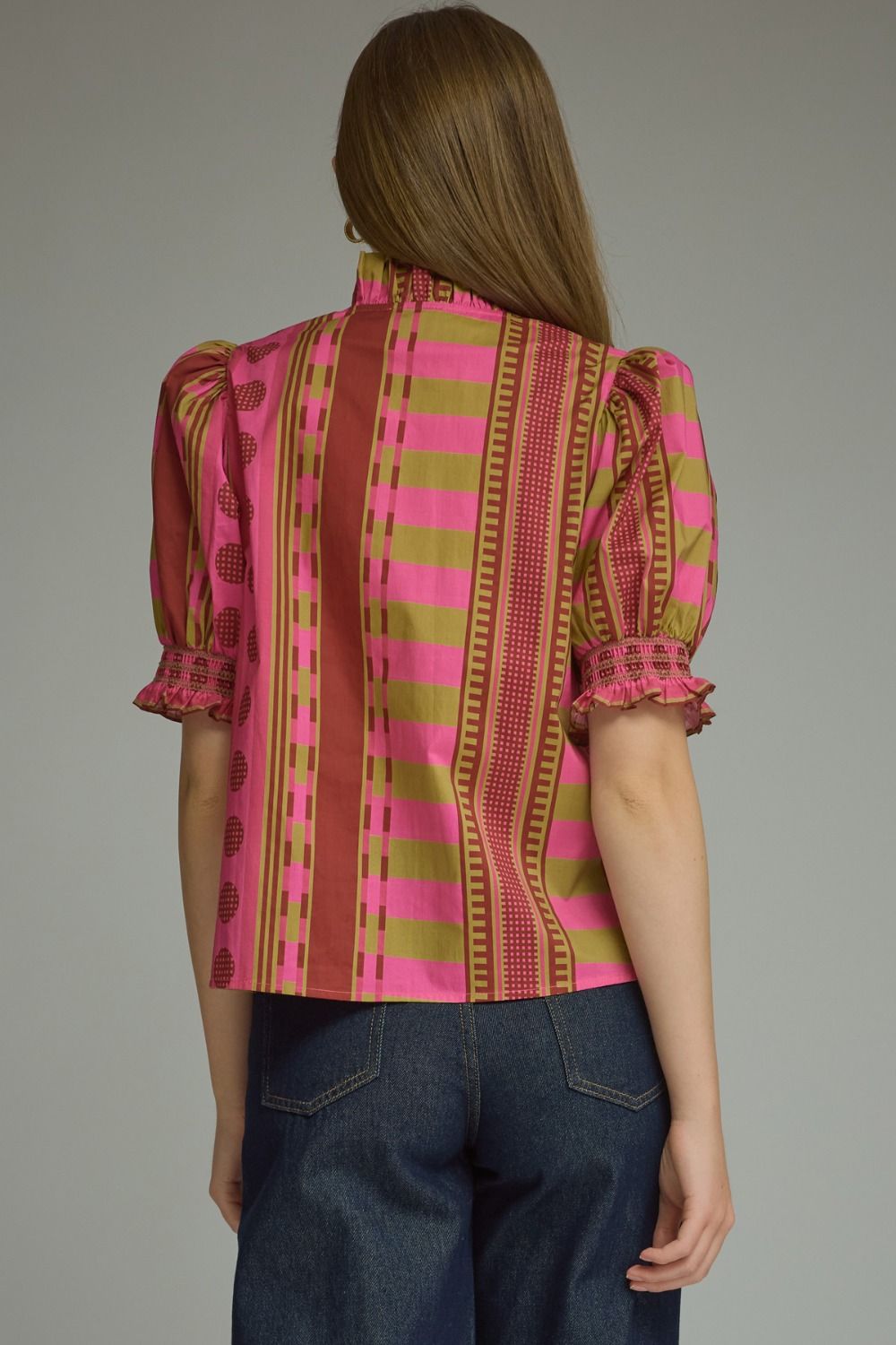 A model styling the Stripes and Dots Blouse in pink and chartreuse by Entro, from Chatsworth Boutique in Fairhope, Alabama.